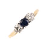 An 18ct gold sapphire and diamond three-stone ring. The circular-shape sapphire and brilliant-cut