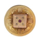 Three brooches. To include a late 19th century 9ct gold ruby and split pearl circular brooch, a