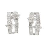 A pair of 18ct gold diamond earrings. Each designed as two brilliant-cut diamond floral clusters,