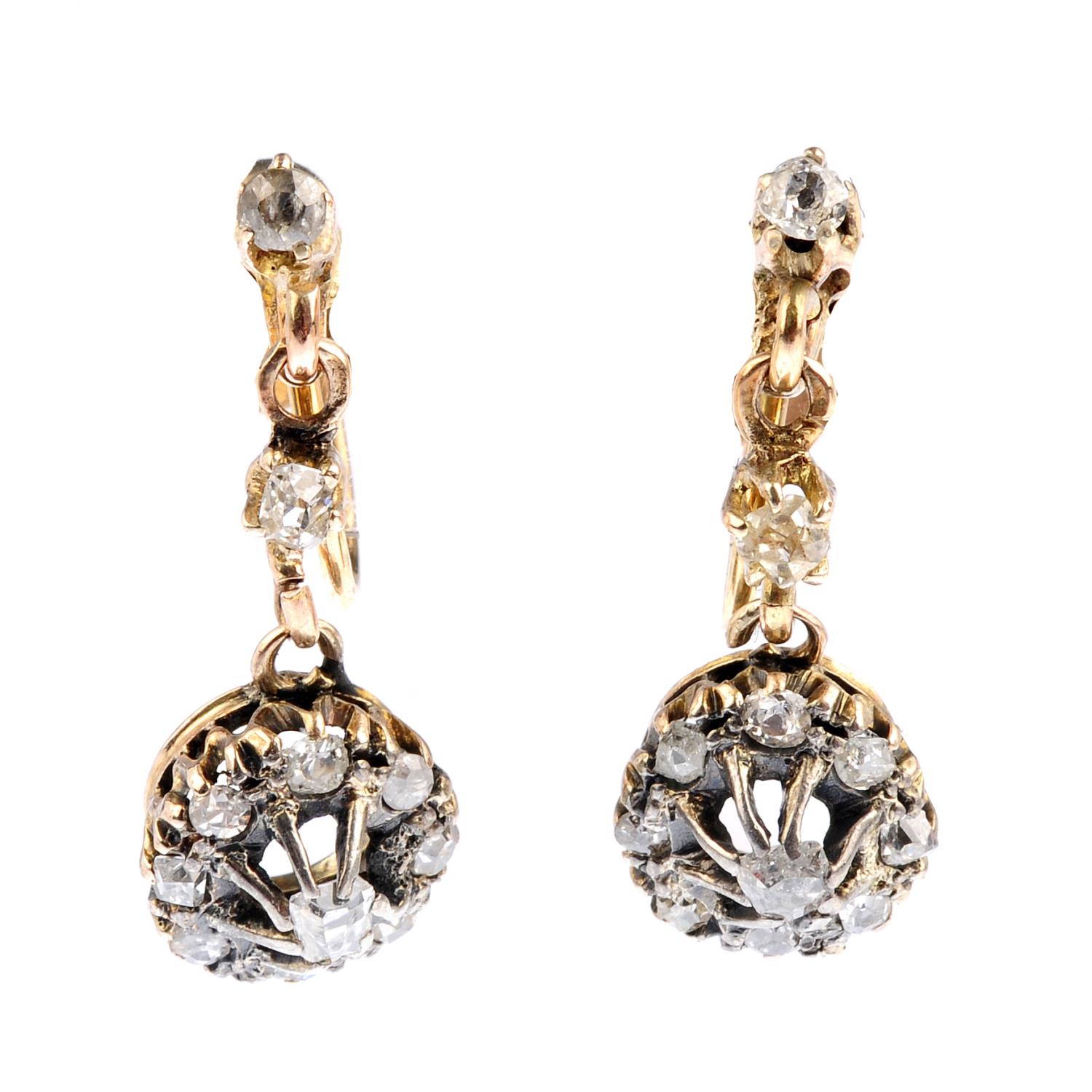 A pair of diamond earrings. Each designed as an old-cut diamond cluster drop, suspended from a