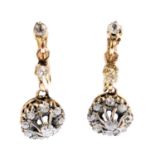 A pair of diamond earrings. Each designed as an old-cut diamond cluster drop, suspended from a