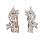 A pair of diamond earrings. Each designed as three brilliant-cut diamond off-set lines, one with