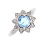 A 9ct gold diamond and topaz cluster ring. The blue topaz cabochon, with a single-cut diamond