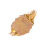 A gentleman's early 20th century 9ct gold signet ring. Designed as a polished shield, with grooved