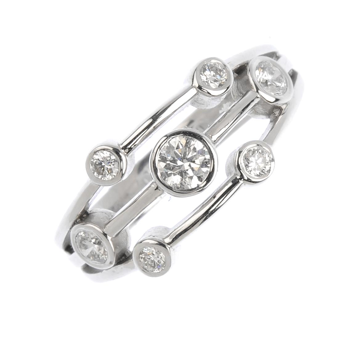 An 18ct gold diamond dress ring. Of openwork design, the graduated brilliant-cut diamond collets