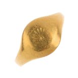 An early 20th century 18ct gold signet ring. The partially engraved front, with tapered shoulders.