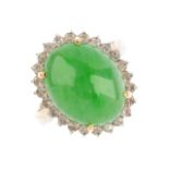 A jade and diamond dress ring. The oval jadeite cabochon, with brilliant-cut diamond surround and