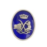 An enamel crest brooch. Of oval outline, the blue enamel panel with textured motif overlay depicting