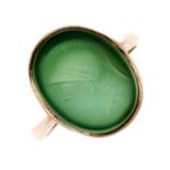 A carved intaglio ring. The collet-set oval-shape green chalcedony intaglio carved with the head