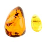 Two pieces of natural Dominican amber with insect inclusions. The first an oval shape piece, with