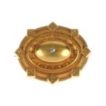 A late Victorian diamond brooch. Of oval outline, the diamond set to the centre of a domed panel,