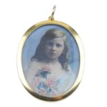 An early 20th century 15ct gold portrait pendant. Of oval-outline, with a glazed panel front and