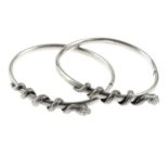 A selection of silver and white metal bangles. To include an open bangle of chevron design, set with