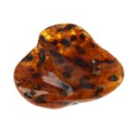 A piece of modified Baltic amber. Of roughly heart-shape, the narrow side with a hole to the centre.