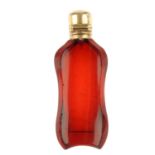 An early 20th century gold topped scent bottle. Of red-colour glass, the bottle with concave front