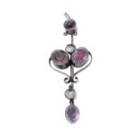 An Arts and Crafts amethyst and mother-of-pearl brooch. Designed as a circular amethyst, to a bar