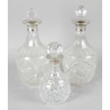 A pair of cut glass decanters, each with applied London 1963 hallmarked silver collars and