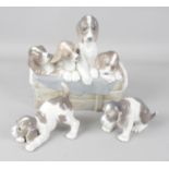 Three Lladro figurines modelled as dogs, the largest example modelled as four hounds peering out