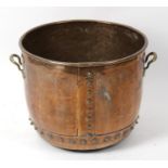 A large 19th century copper log bin. The hammered cylindrical body with rolled rim over studded