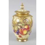 A Royal Worcester bone china vase with pierced cover, hand painted with fruit, signed Freeman. 6.