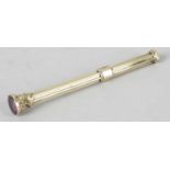 A yellow metal slide action propelling pencil, the reeded case with amethyst stone set seal to