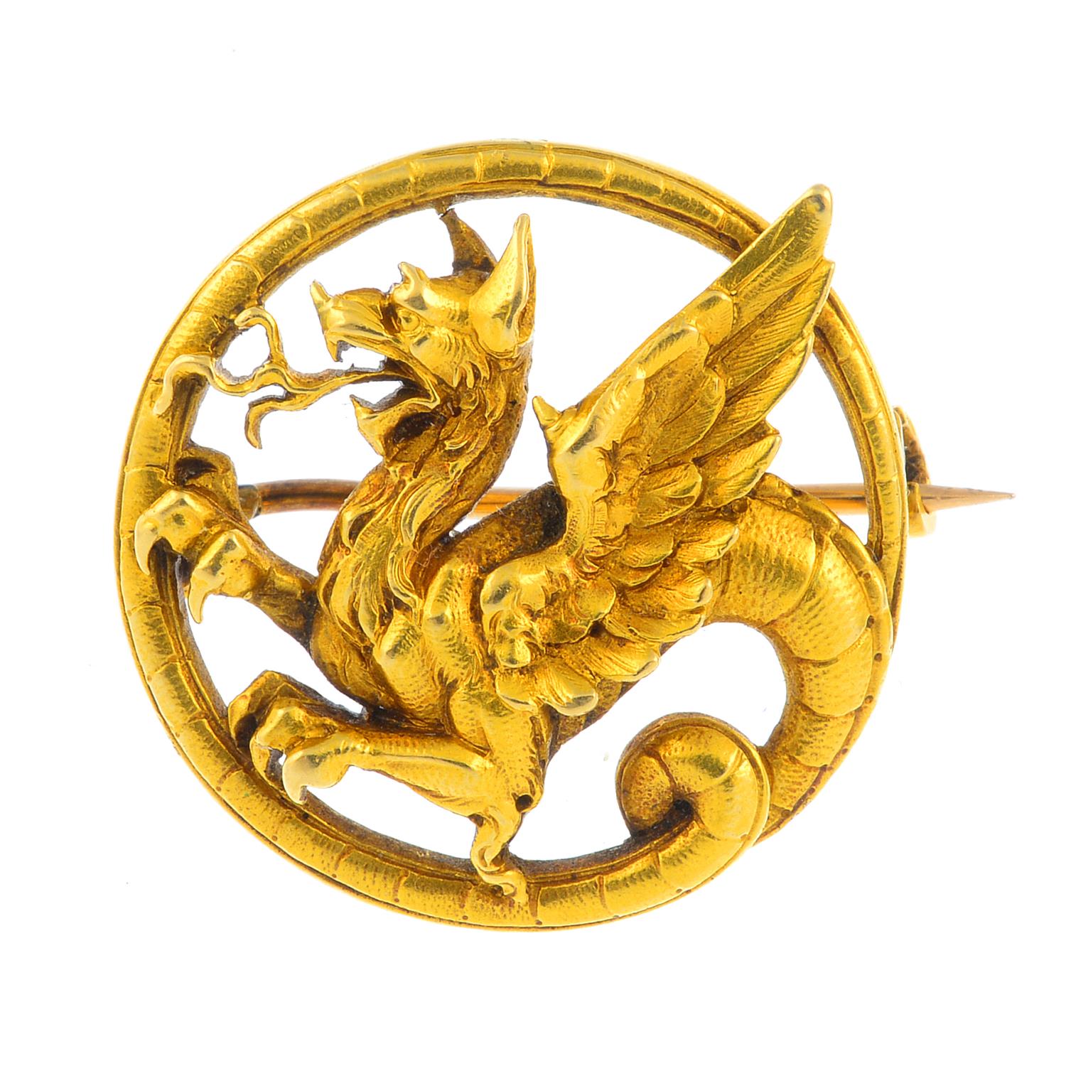 A mid Victorian gold brooch, circa 1870. Designed as a textured chimera, its scrolling tail