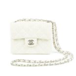 CHANEL - a Mini Classic Flap handbag. Designed with a quilted cream perforated leather exterior