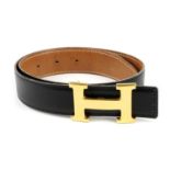 HERMÈS - a reversible logo buckle belt. Designed with smooth black leather to one side and grained