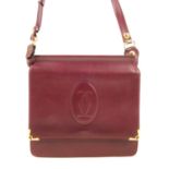 CARTIER - a reversible Must De Cartier Bordeaux messenger handbag. With front and rear compartments,