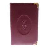 CARTIER - a Must De Cartier Bordeaux leather writing cover with inserts. Featuring a smooth burgundy