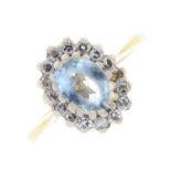 An 18ct gold aquamarine and diamond cluster ring. The oval-shape aquamarine, within a single-cut