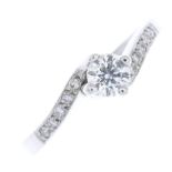 A 9ct gold diamond ring. The brilliant-cut diamond, with similarly-cut diamond line crossover