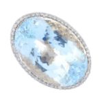 An aquamarine and diamond dress ring. The oval-shape aquamarine, with brilliant-cut diamond surround