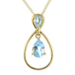 A 9ct gold topaz pendant. The pear-shape blue topaz, suspended within a tapered surround, to the