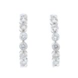 A pair of 18ct gold diamond earrings. Each designed as a brilliant-cut diamond collet half-hoop.