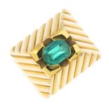 An emerald dress ring. The oval-shape emerald, raised to the grooved geometric surround and band.