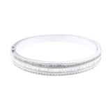 A diamond hinged bangle. The baguette-cut diamond line, with brilliant-cut diamond line sides, inset