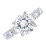 A diamond single-stone ring. The brilliant-cut diamond, with similarly-cut diamond line shoulders.