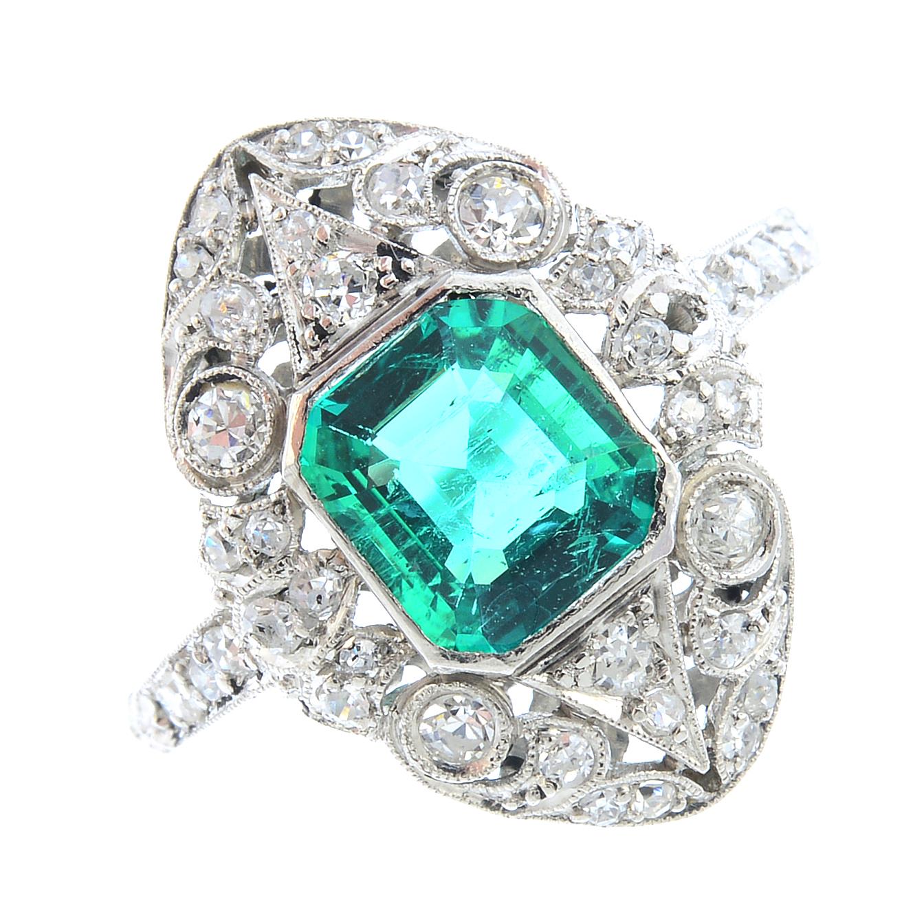A Columbian emerald and diamond ring. Of openwork design, the square ...