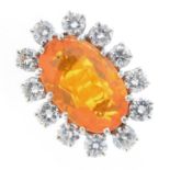 An 18ct gold fire opal and diamond cluster ring. The oval fire opal, with brilliant-cut diamond