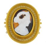 A late Victorian gold onyx cameo clasp. The oval onyx, carved to depict Hera, with enamel accent