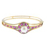 A natural pearl, Burmese ruby and diamond hinged bangle. Of openwork design, the pearl, measuring