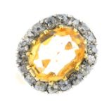 A mid 19th century topaz and diamond cluster ring. The oval-shape orange topaz and old-cut diamond