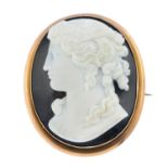 A late Victorian gold onyx cameo brooch. Of oval outline, carved to depict a lady in profile, with