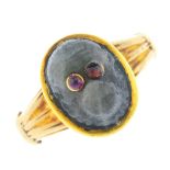 A labradorite and ruby ring. The labradorite carved to depict a monkey face, with circular-shape