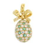 A diamond and emerald pendant. Designed as a pave-set diamond and emerald egg, suspended from a