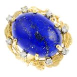 A mid 20th century lapis lazuli and diamond dress ring. The oval lapis lazuli cabochon, with