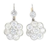 A pair of diamond cluster earrings. Each designed as a brilliant-cut diamond scalloped cluster,