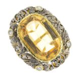 A citrine and diamond ring. Of bi-colour design, the oval-shape citrine collet, within a brilliant-