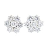 A pair of diamond earrings. Each designed a brilliant-cut diamond floral cluster. Estimated total